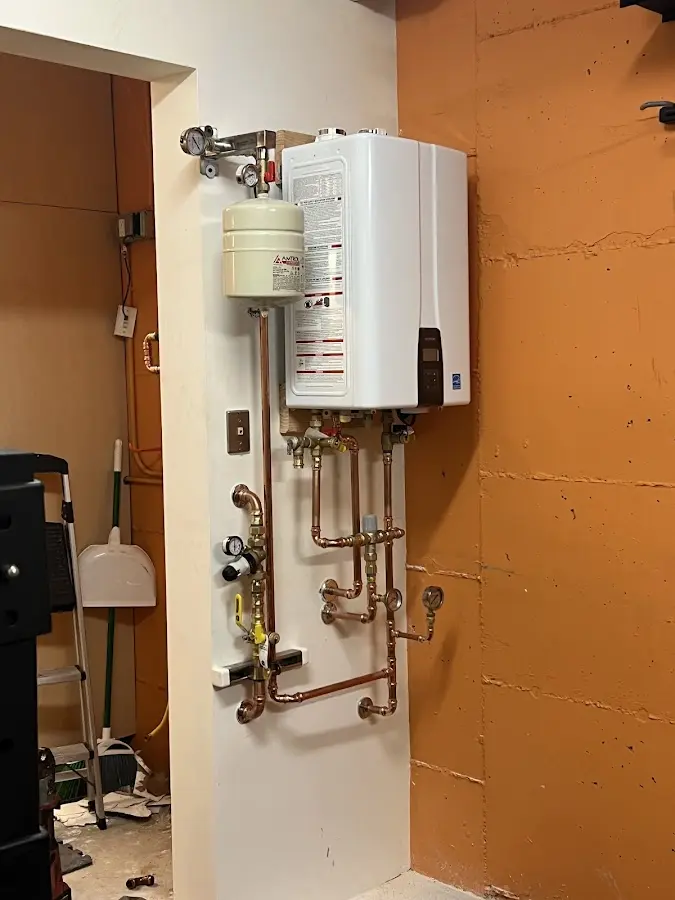 Plumbing technician inspecting water heater connections in Fountain